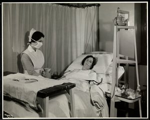 ممرضة مقنعة مع مريض في غرفة في مستشفى سلون الطبي ، برودواي وشارع 168 ، نيويورك ، 1932 (طباعة الجيلاتين الفضي)